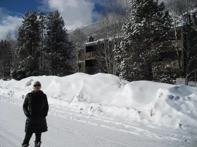 a person standing on a snow covered road at Heart of Frisco Condo in Frisco