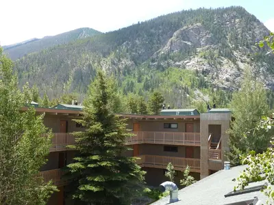 a building with a mountain in the background at Heart of Frisco Condo in Frisco