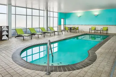 a pool in a hotel room with chairs and tables at SpringHill Suites Denver at Anschutz Medical Campus in Aurora