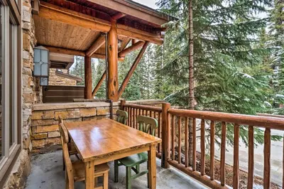 a wooden table and chairs on a balcony of a cabin at The Timbers Ski-In, Ski-Out 1 Bedroom Plus Murphy in Keystone