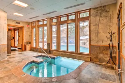 a hot tub in the middle of a room with windows at The Timbers Ski-In, Ski-Out 1 Bedroom Plus Murphy in Keystone