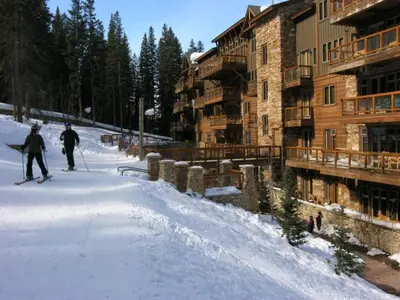 two people on skis in the snow next to a lodge at The Timbers Ski-In, Ski-Out 1 Bedroom Plus Murphy in Keystone