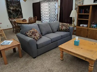 a living room with a blue couch and a table at Columbine Cabins in Grand Lake
