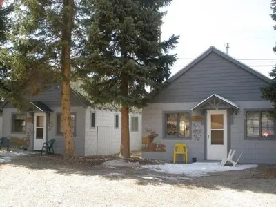 a white house with trees in front of it at Columbine Cabins in Grand Lake