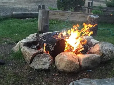 a fire pit with rocks in the grass at Columbine Cabins in Grand Lake