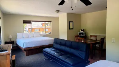 a bedroom with a bed and a couch and a table at Murphy's River Lodge in Estes Park