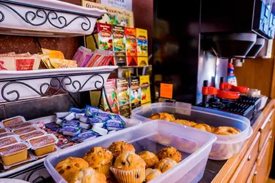 a bakery with muffins and other food on a counter at Murphy's River Lodge in Estes Park