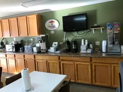 a kitchen with a counter with a tv on the wall at Super 8 by Wyndham Kremmling in Kremmling
