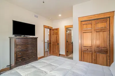 a bedroom with a bed and a flat screen tv at Coyote Ridge Condo in Estes Park