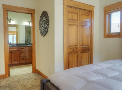a bedroom with a bed and a bathroom with a mirror at Coyote Ridge Condo in Estes Park