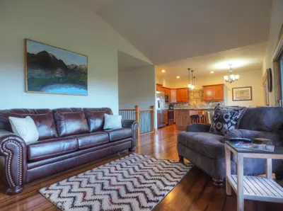 a living room with two leather couches and a kitchen at Coyote Ridge Condo in Estes Park
