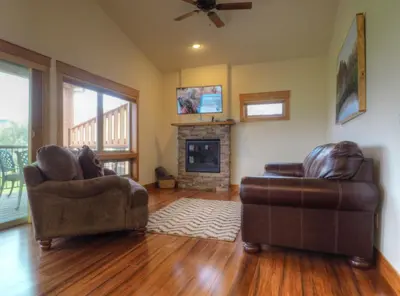 a living room with two chairs and a fireplace at Coyote Ridge Condo in Estes Park