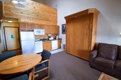 a small kitchen with a table and a refrigerator at The Inn at Silvercreek in Granby