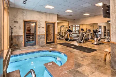 a gym with a swimming pool and exercise equipment at Ski-In, Ski-Out 1 Bedroom Plus Murphy At The Timbers in Keystone