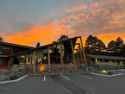 a building with a sunset in a parking lot at Trailhead Lodge in Estes Park