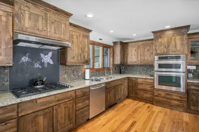 a kitchen with wooden cabinets and stainless steel appliances at Snowline Vista Lodge in Estes Park