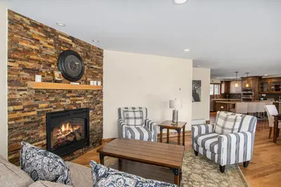 a living room with a fireplace and two chairs at Snowline Vista Lodge in Estes Park