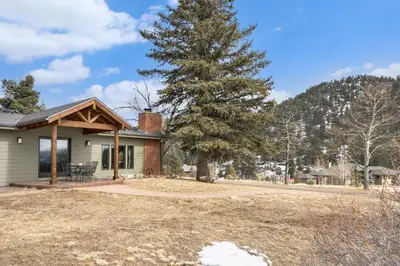 a house with a tree in the yard at Snowline Vista Lodge in Estes Park