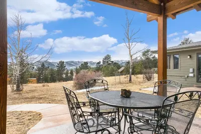 a table and chairs on a patio with a view at Snowline Vista Lodge in Estes Park