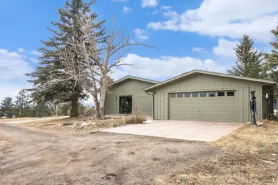 a house with a garage on a dirt road at Snowline Vista Lodge in Estes Park