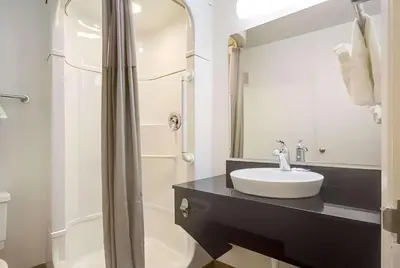 a white bathroom with a sink and a shower at Park Inn by Radisson, Lakewood in Lakewood