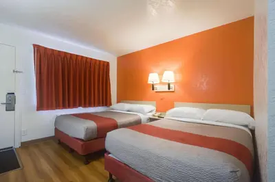 two beds in a room with orange walls at Park Inn by Radisson, Lakewood in Lakewood
