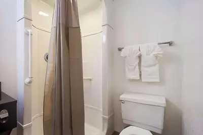 a bathroom with a toilet and a shower with towels at Park Inn by Radisson, Lakewood in Lakewood