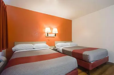 two beds in a small room with orange walls at Park Inn by Radisson, Lakewood in Lakewood