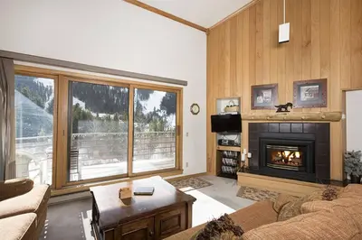 a living room with a fireplace and a large window at Ski Run - Mountain House Keystone in Keystone