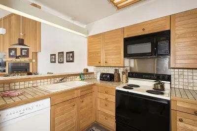 a kitchen with wooden cabinets and a stove top oven at Ski Run - Mountain House Keystone in Keystone