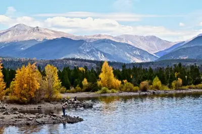 a person standing on a rock in the middle of a river at Ski Run - Mountain House Keystone in Keystone