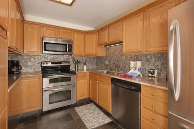 a kitchen with wooden cabinets and stainless steel appliances at Snowdance - Keystone in Dillon