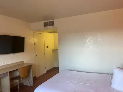 a room with a bed and a desk and a television at Motel 6 Fort Collins, CO in Fort Collins