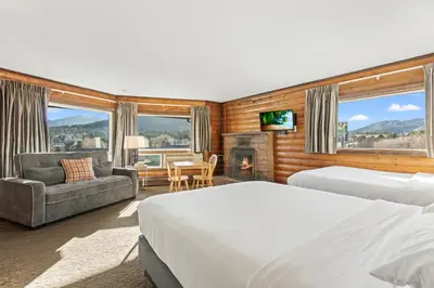 a hotel room with two beds and a fireplace at Discovery Lodge in Estes Park