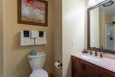 a bathroom with a toilet and a sink and a mirror at Discovery Lodge in Estes Park