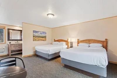 a hotel room with two beds and a table at Discovery Lodge in Estes Park