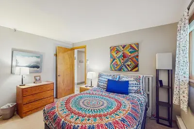 a bedroom with a king sized bed with a colorful bedspread at La Bonte Leisure Beauty in Dillon