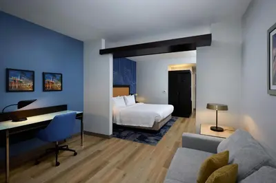 a hotel room with a bed and a desk and a bedroom at Fairfield Inn & Suites by Marriott Denver Downtown in Denver