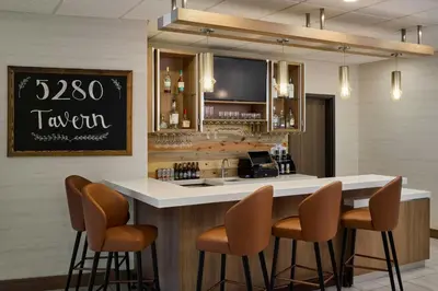 a bar with three stools and a counter with a bar counter at Fairfield Inn & Suites by Marriott Denver Downtown in Denver