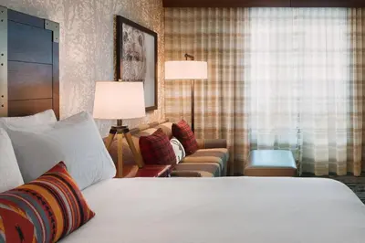 a hotel room with a bed and a couch at Gaylord Rockies Resort & Convention Center in Aurora
