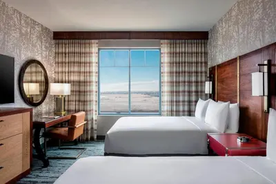 a hotel room with a bed and a desk and a window at Gaylord Rockies Resort & Convention Center in Aurora