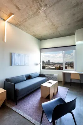 a living room with a blue couch and a large window at The Source Hotel in Denver