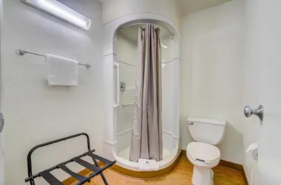 a white bathroom with a shower and a toilet at Motel 6 Thornton in Thornton
