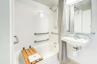 a white bathroom with a sink and a bath tub at Motel 6 Thornton in Thornton