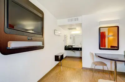 a living room with a table and a mirror at Motel 6 Thornton in Thornton
