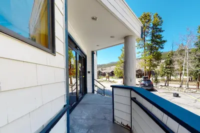 a porch of a white house with a blue railing at 2914 River Bank Lodge - Keystone in Keystone