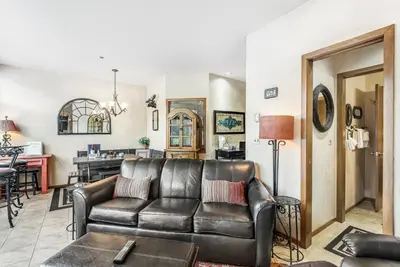 a living room with a leather couch and a kitchen at 2914 River Bank Lodge - Keystone in Keystone