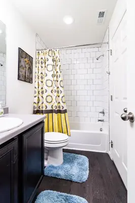 a bathroom with a tub and a toilet and a sink at Den Haven Entire Home Near DIA With Three Bedrooms And Private En Suite Baths in Denver