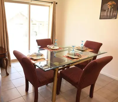 a dining room table with chairs and a glass table top at Den Haven Entire Home Near DIA With Three Bedrooms And Private En Suite Baths in Denver