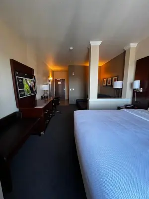 a hotel room with a bed and a desk and a tv at Comfort Suites Denver International Airport in Denver